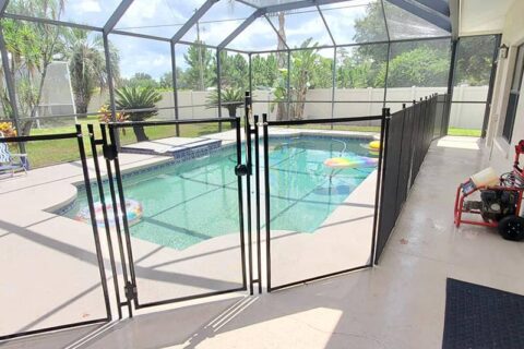 A pool fence surrounds a swimming pool, featuring a secure gate for safety and access control.