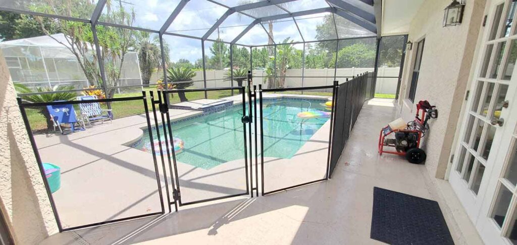 A pool fence surrounds a swimming pool, featuring a secure gate for safety and access control.