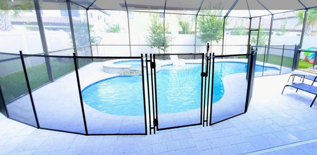 A pool area featuring a fenced perimeter and a pool table nearby, emphasizing recreational space and safety.